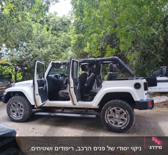 רכב שטח לבן עם דלתות פתוחות בחניה